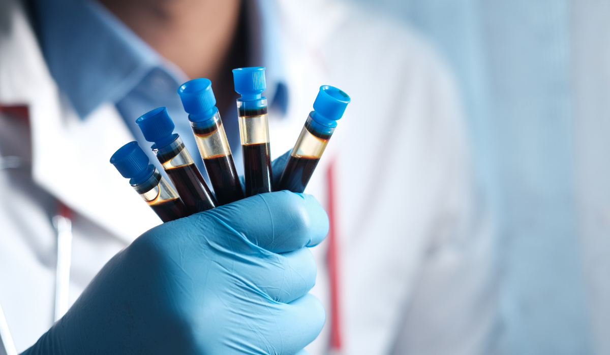 Gloved technician holding a handful of labelled sample tubes